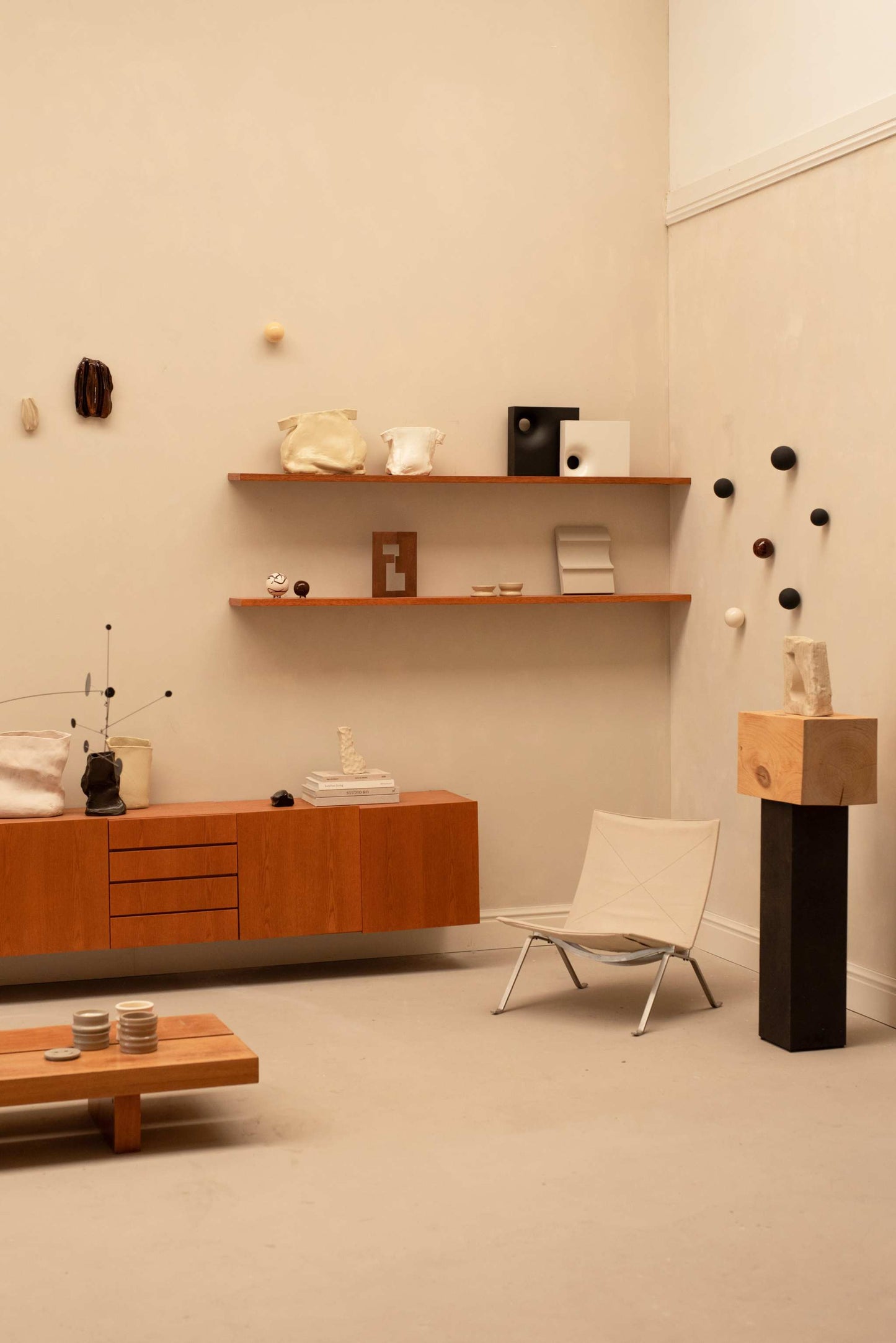 Handcrafted ceramic vase object displayed in minimalist modern interior with wooden shelves and neutral decor