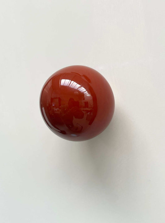 Ceramic ball in rust burgundy color wall sculpture.