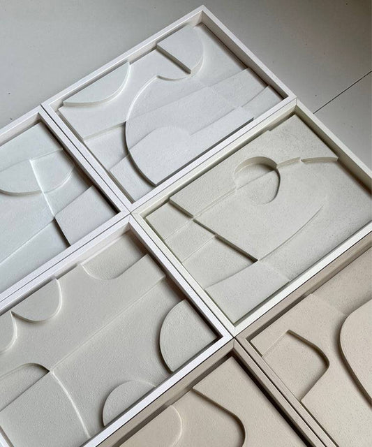 Handmade geometric art pieces in white frames made from biodegradable PLA with unique sand texture.