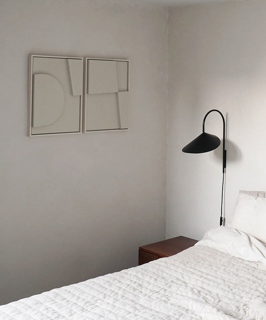 Minimalist art pieces 'Shape #6.1 + #6.2' on a bedroom wall, hand-made from biodegradable PLA with sand texture and eco-paint.