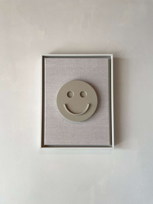 Canvas artwork titled "Canvas Happy" with shadow white frame and a smile motif on a brown wood background.