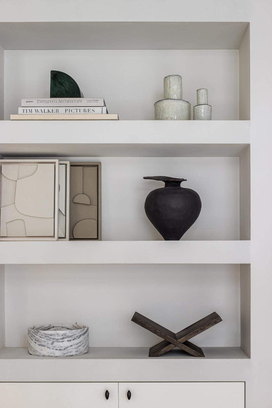 Hand-crafted art pieces on minimalistic shelves.