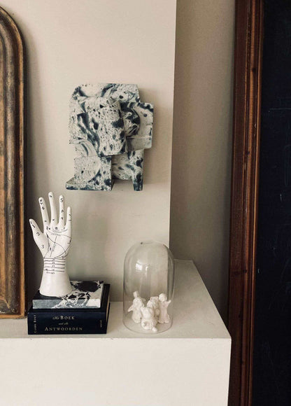 Mien Sculpture Small Marble wall art with organic form and hand-painted finish, displayed indoors on a shelf.