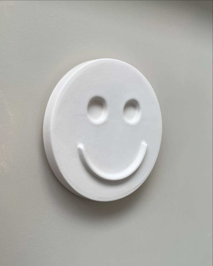 white ceramic wall art with smiley face handcrafted by Edith Beurskens