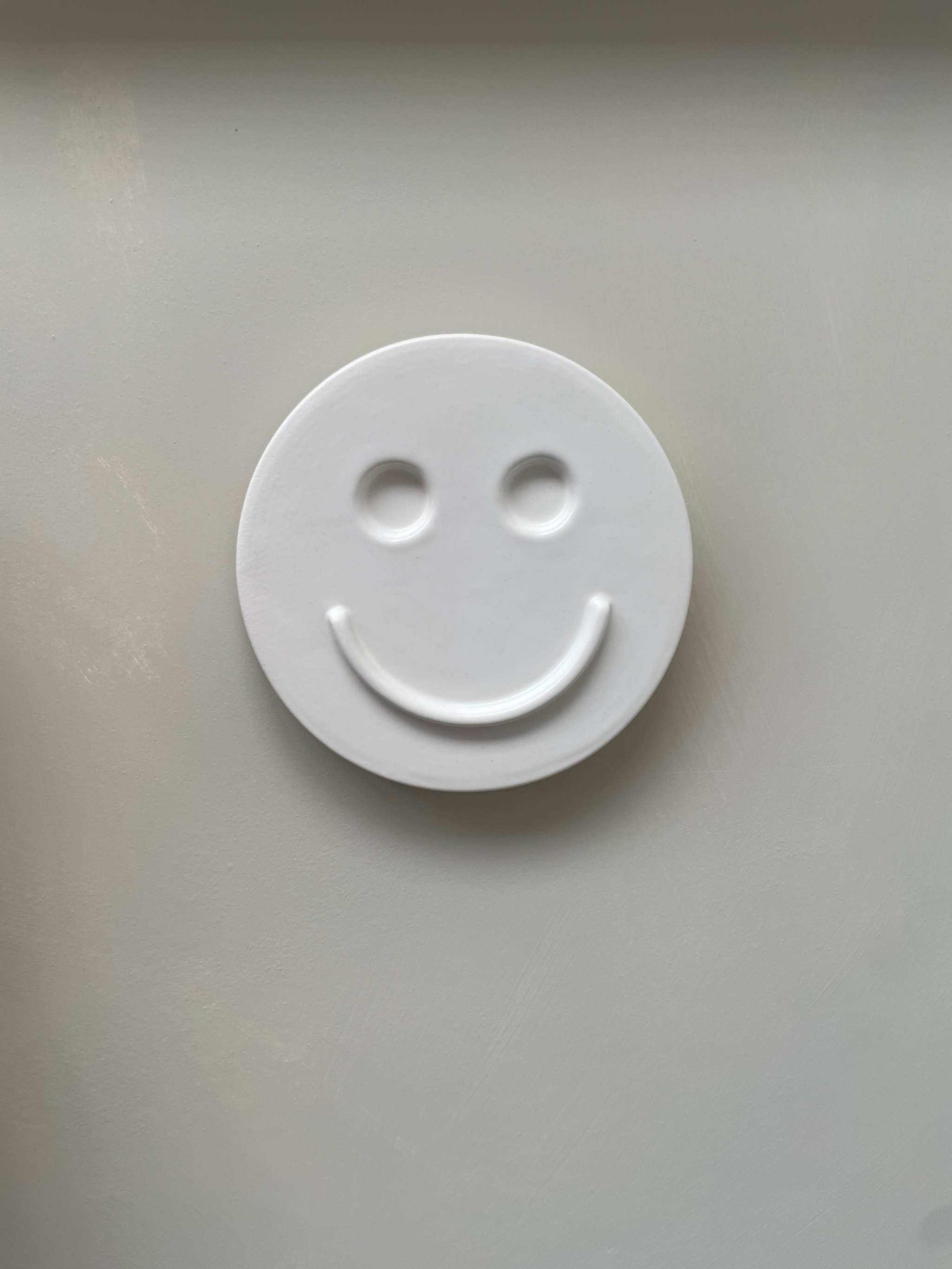 white ceramic wall art smiley face decorative wall hanging handcrafted by Edith Beurskens Royal Goedewaagen