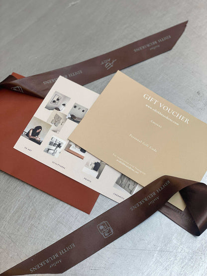 Gift Voucher with collection card and color swatches on table.