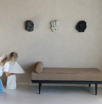 Organic wall sculptures with hand-painted finish, displayed above a minimalist couch.