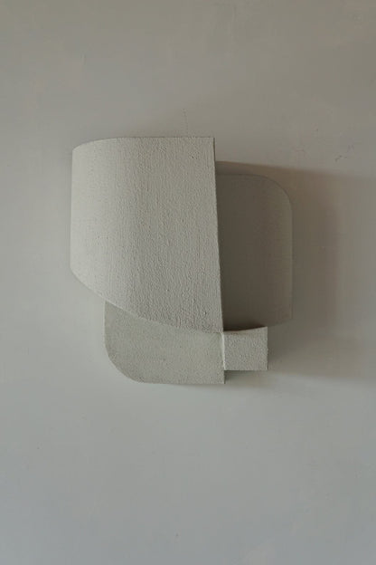 Elegant sand-colored wall sculpture with organic form and hand-painted finish.