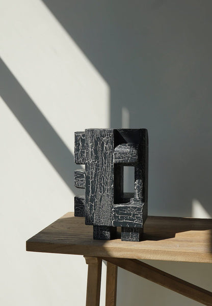 Odile Sculpture with crackle finish on wooden table in sunlight.