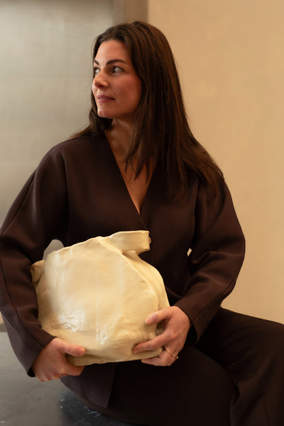 Woman holding a unique handcrafted ceramic vase object with organic texture and form