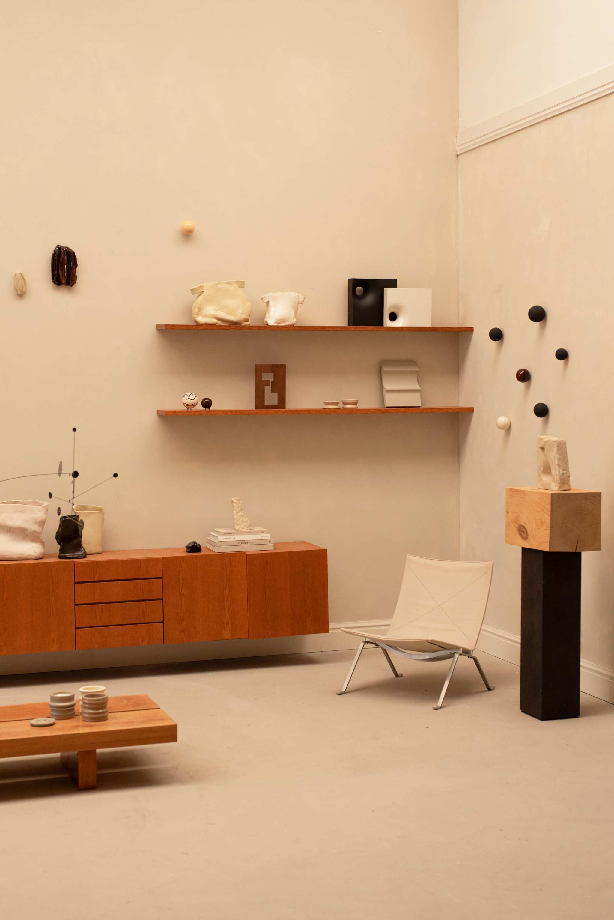 Handcrafted ceramic vase object displayed in minimalist modern interior with wooden shelves and neutral decor