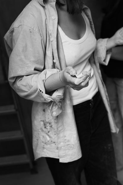 Private throwing wheel lesson participant holding clay in a cozy atelier.