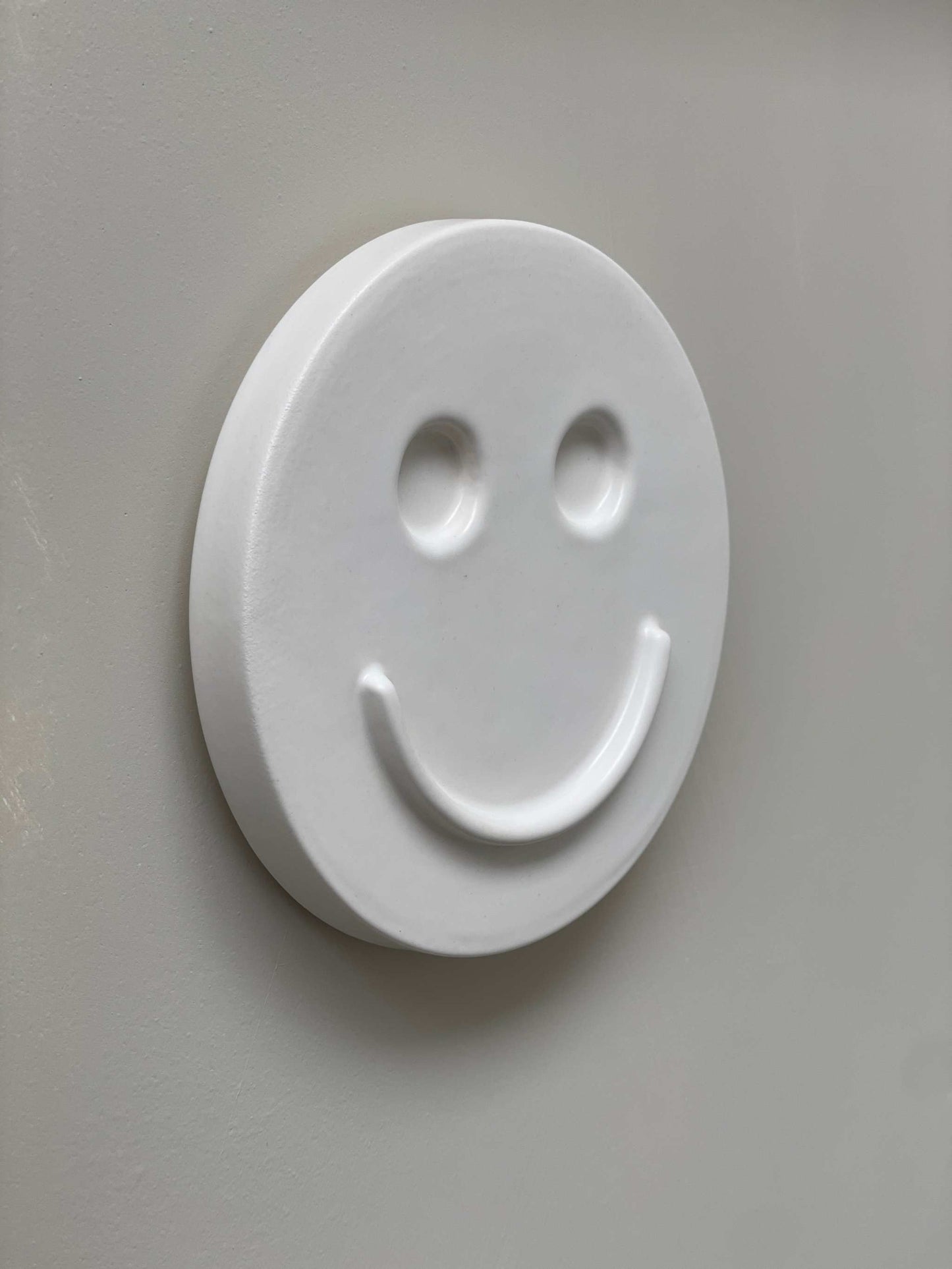 white ceramic wall art smiley face handcrafted by Edith Beurskens for kids room decoration