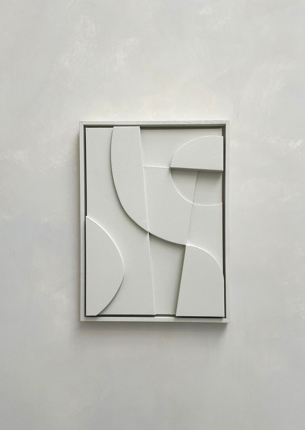 Minimalist abstract canvas print with geometric shapes in a white frame.