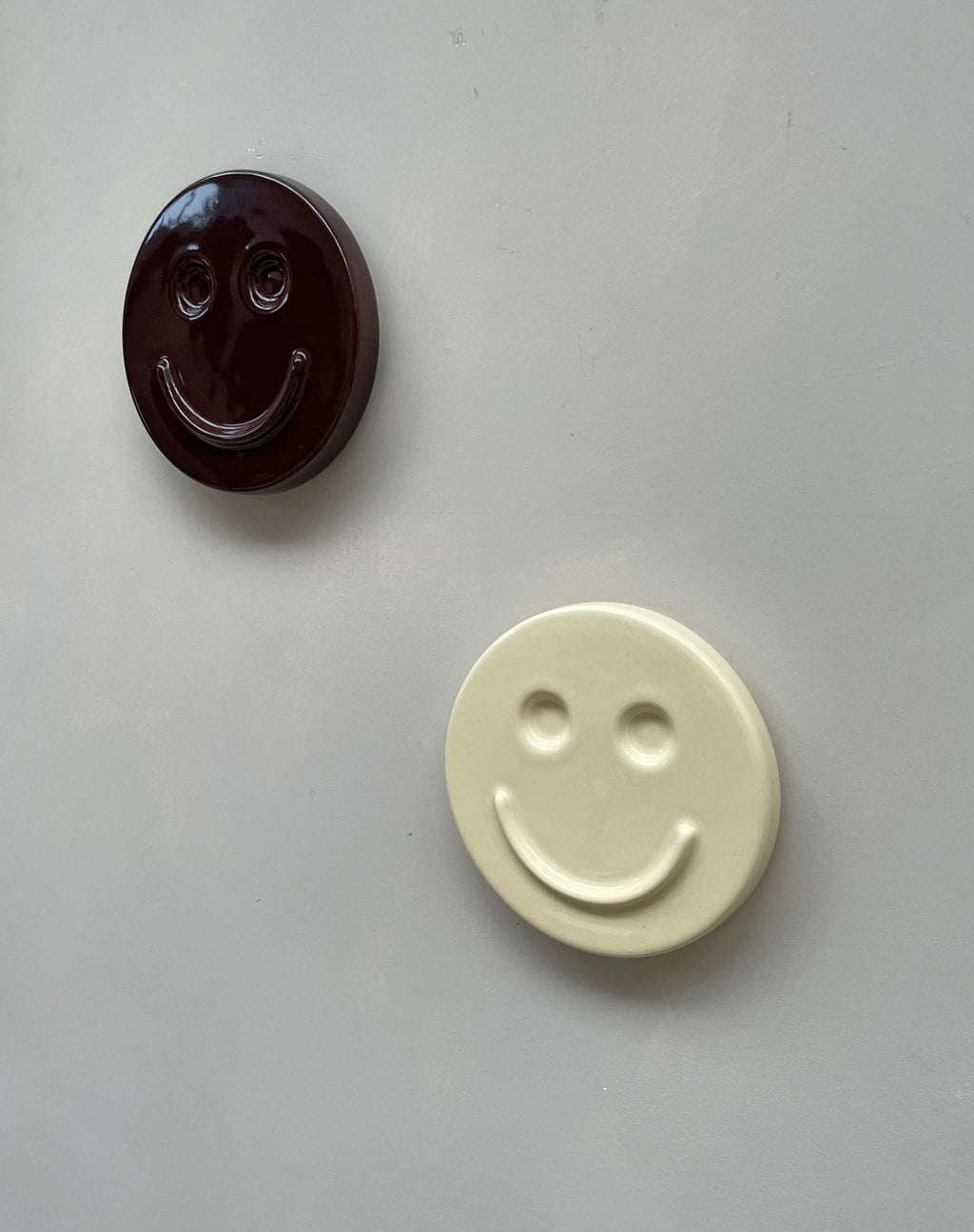 Butter 'HAPPY' ceramic artwork, handcrafted smiley face design.