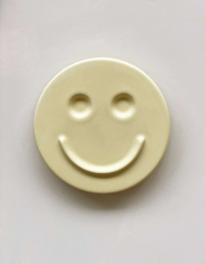 Butter 'HAPPY' ceramic artwork with a smiley face design.