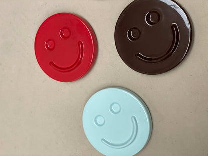 Colorful eggplant SMILE ceramic artworks by Edith Beurskens.