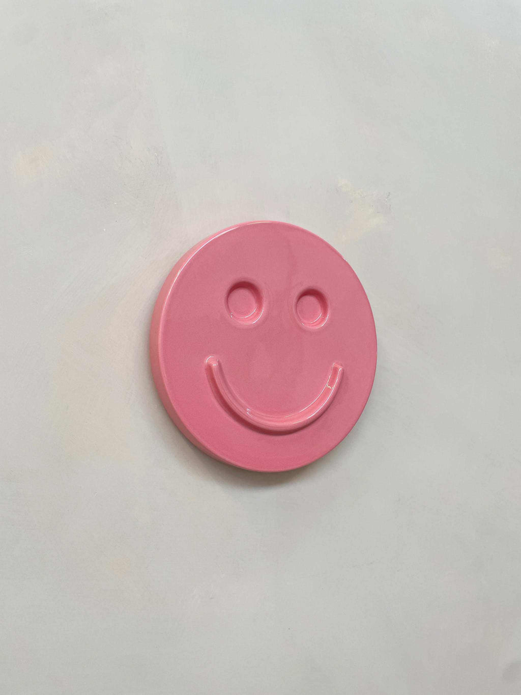 Pink 'HAPPY' ceramic artwork by Edith Beurskens, handcrafted with glaze.