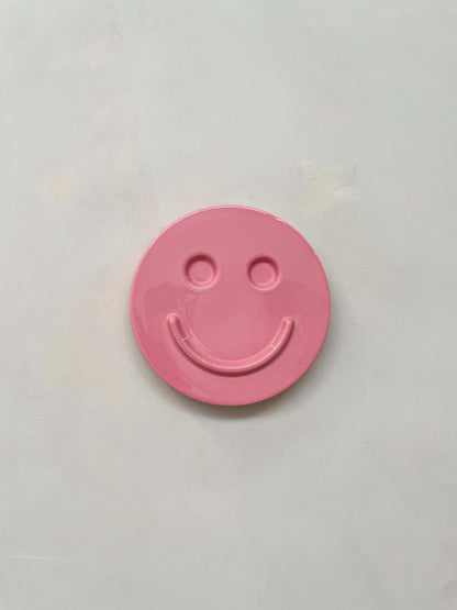 Pink ceramic smiley face artwork by Edith Beurskens, handcrafted and glazed.