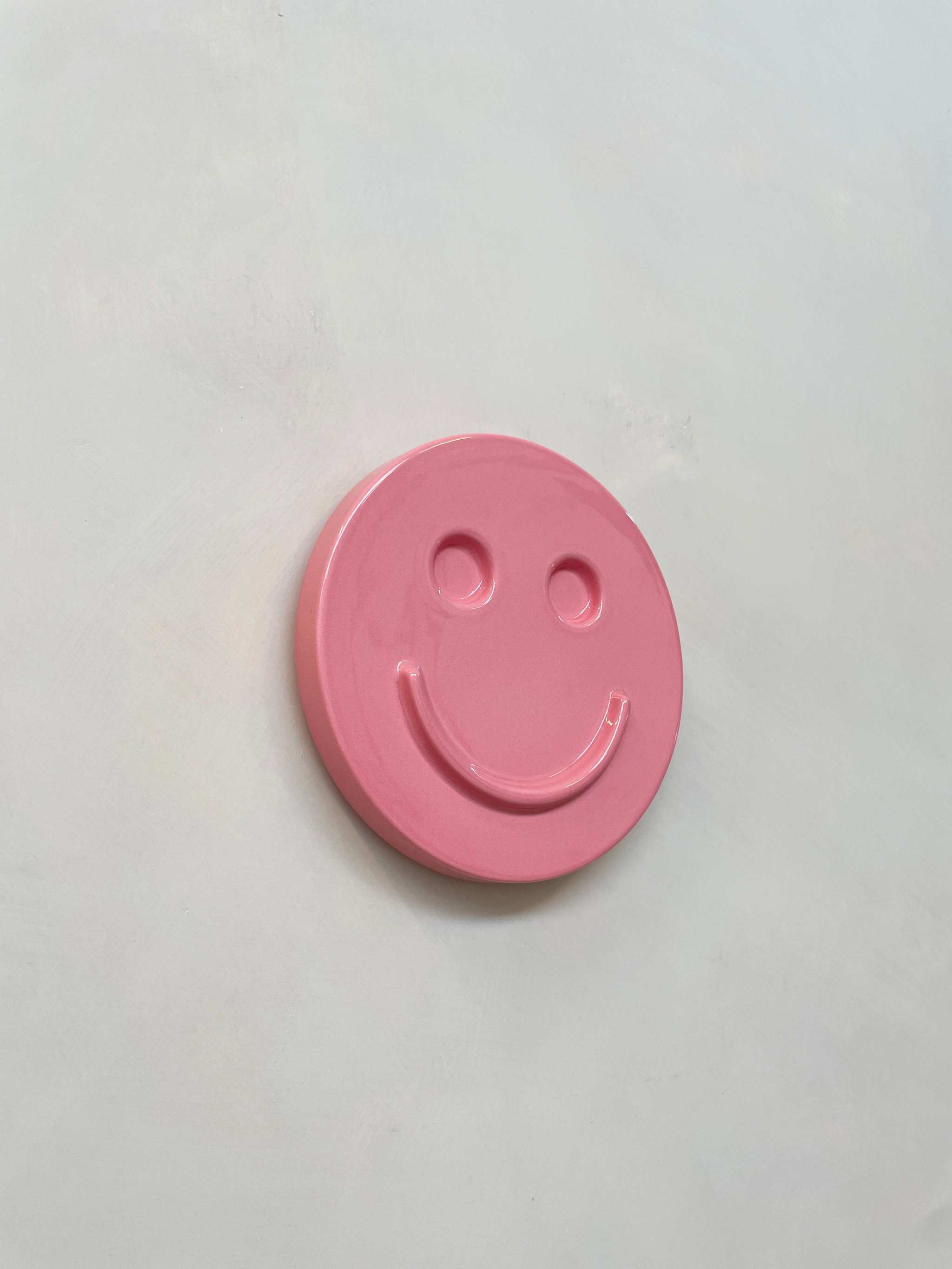 Pink HAPPY ceramic artwork with smiley design, handcrafted by Edith Beurskens.
