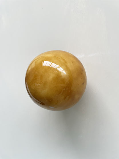 Handcrafted ceramic ball in cognac color, wall sculpture by Edith Beurskens and April van Domburg.