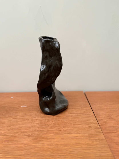 Handcrafted unique ceramic vase object 02 with abstract twisted design in dark finish on wooden surface