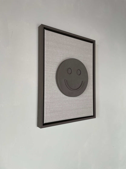 Canvas Happy artwork with biodegradable PLA base and structured plaster finish in a 43x33.5 cm frame.