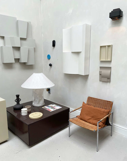 Modern interior with ELEMENT BRUTALIST artwork, featuring plant-based PLA material and structured plaster finish, shadow white color, on wall.