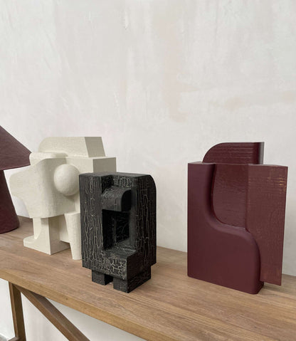 Odile sculpture with crackle finish in organic architectural form on wooden surface.