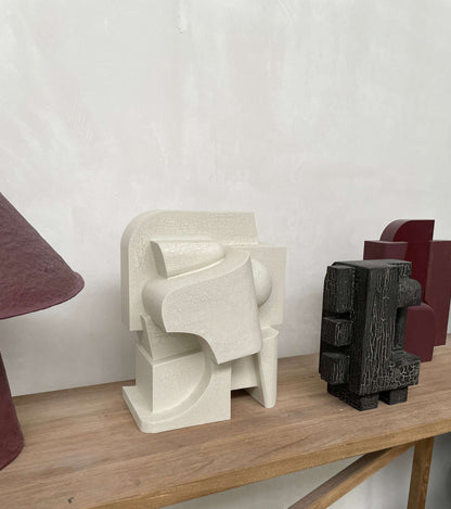 Odile hand-painted wall sculpture with organic, architectural design on display shelf.