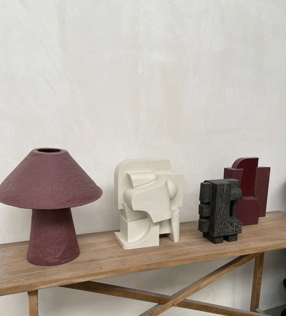 Odile Sculpture on display alongside other abstract sculptures on a wooden shelf.