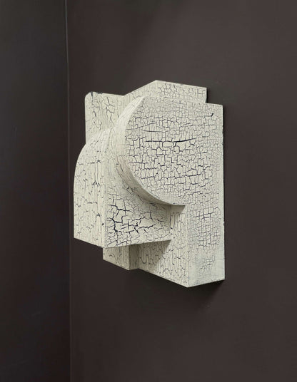 Bep Sculpture with crackle finish mounted on a black wall.