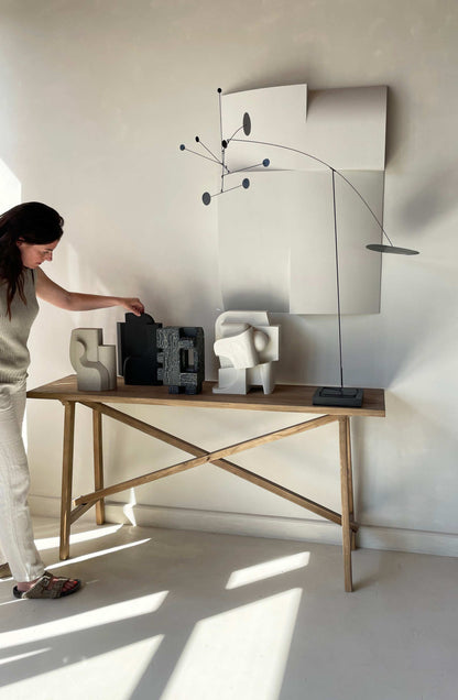 Mien Sculpture in organic form with hand-painted finish, designed by Ilse van Stoltz and Edith Beurskens, showcased on a wooden table.