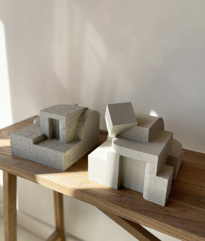 Erica Sculpture in sand color, displaying an organic cubist form with a unique hand-painted finish, placed on a wooden surface.