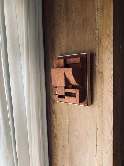 Bepy Sculpture in organic form with hand-painted finish mounted on a wooden wall.