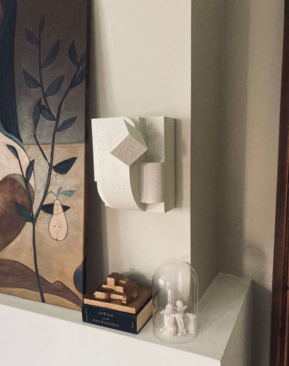 Erica Sculpture in organic form with crackle finish mounted on wall.