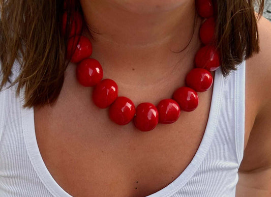 Handmade ceramic bead necklace with large glossy red beads on elastic cord, bold and unique statement jewelry
