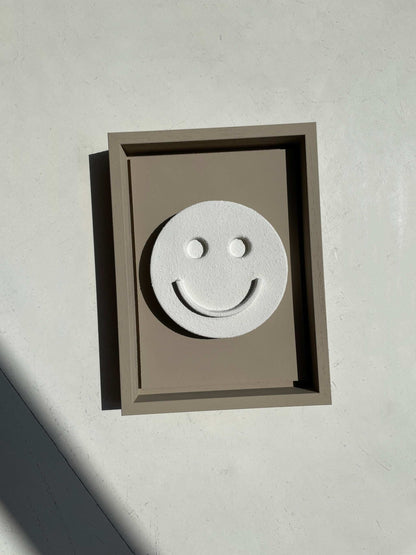 Hand-made 23.5 Happy artwork in eco-friendly PLA with smiley face design, sand texture, beige frame.