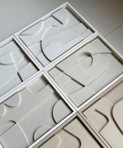 Handmade geometric art pieces in white frames made from biodegradable PLA with unique sand texture.