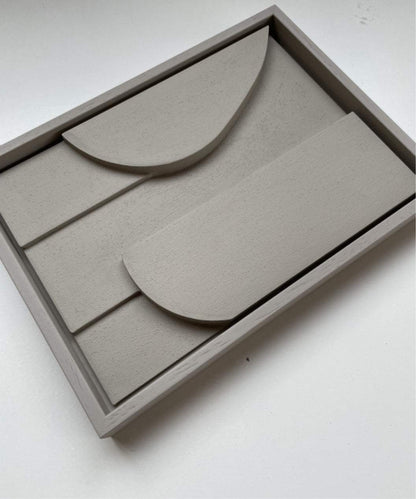 Handmade art piece on a rectangular frame with geometric shapes, plant-based PLA, sand texture, eco-paint.