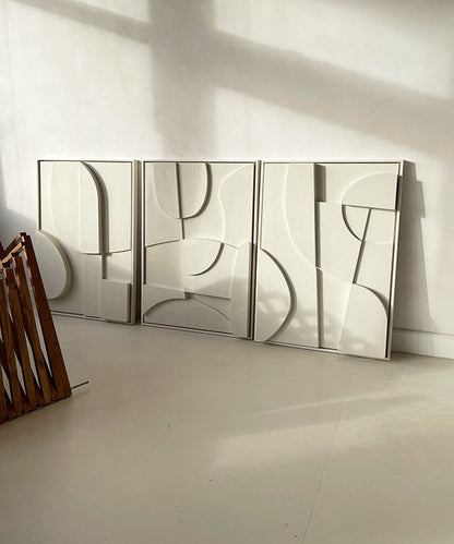 Contemporary hand-made abstract art set in neutral tones displayed against a white wall.