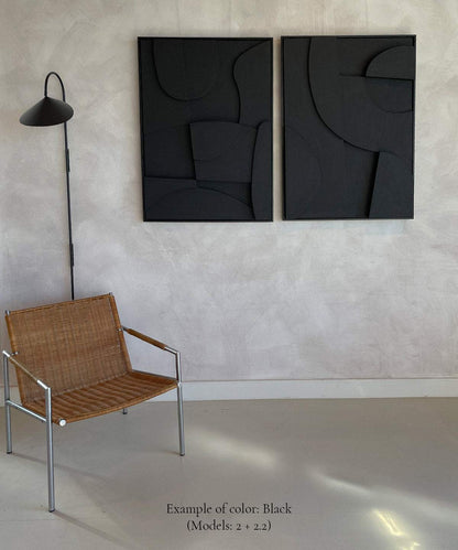 Handmade black wall art composed of plant-based PLA with sand texture, in a minimalist room setting.