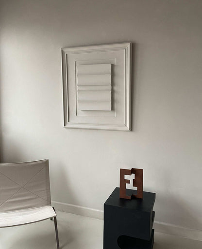 Vintage Frame Large Dunes artwork in shadow white displayed on a wall with a modern chair and sculpture.