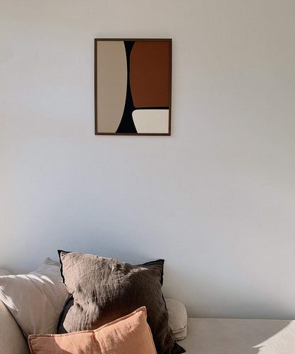 Olivia art print displayed on a wall above a sofa with cushions.