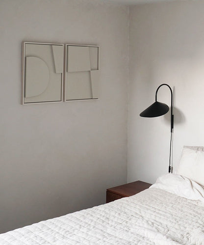 Minimalist art pieces 'Shape #6.1 + #6.2' on a bedroom wall, hand-made from biodegradable PLA with sand texture and eco-paint.