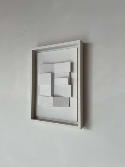 Modern hand-made artwork featuring a zigzag pattern framed on a wall.