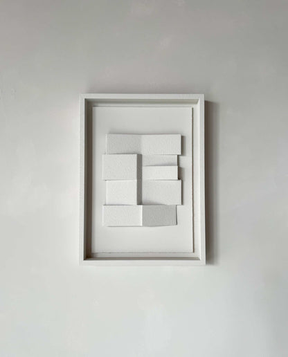 23.4 Zigzag hand-made artwork in white frame on minimalist wall.