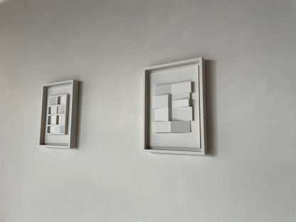 Wall-mounted white framed artworks featuring geometric patterns titled "#23.4 Zigzag."