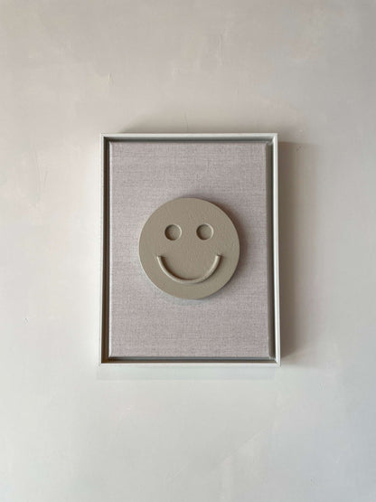 Canvas artwork titled "Canvas Happy" with shadow white frame and a smile motif on a brown wood background.