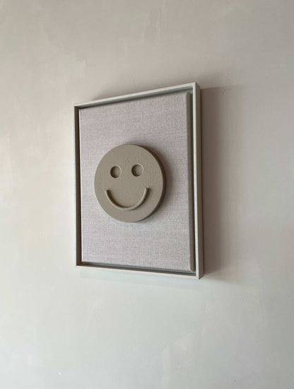 Canvas Happy artwork with biodegradable PLA base and structured plaster finish in a shadow white frame.